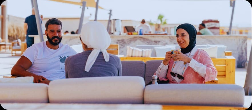 Two delegates in conversation on the beach lounge