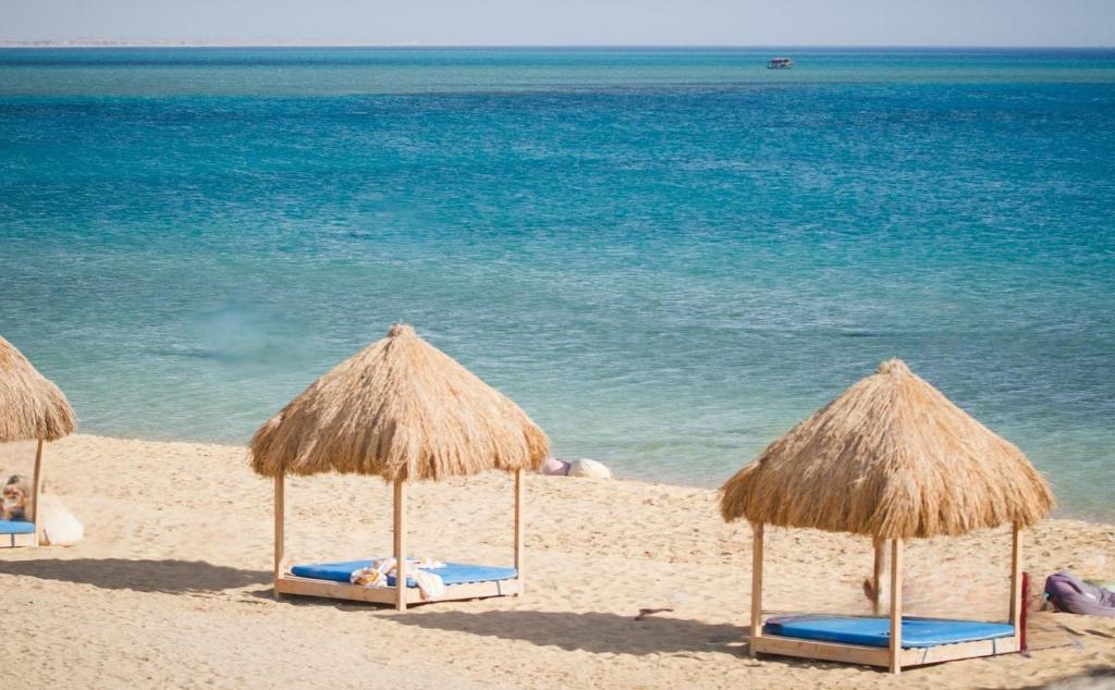 Beach seating at dusk, thatched umbrellas along the shoreline